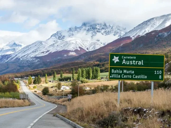 Letrero de la Carretera Austral con montañas nevadas de fondo, cerca de Villa Cerro Castillo