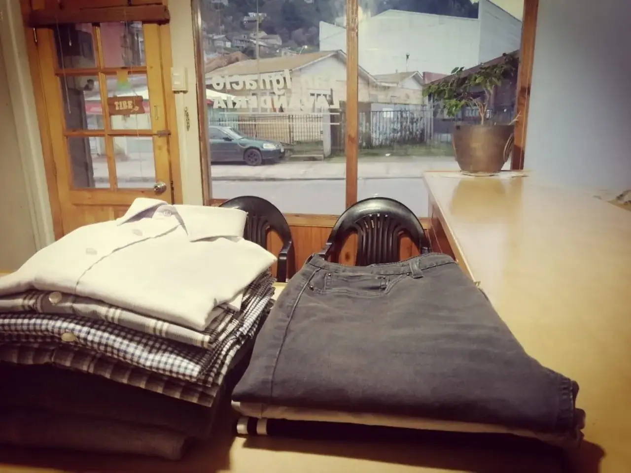 Ropa lavada y doblada sobre el mesón del local